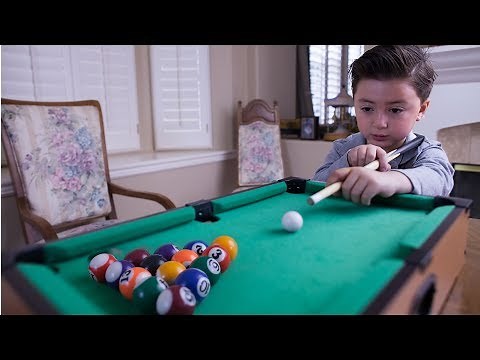 6 Year-old billiard prodigy playing with a mini pool table
