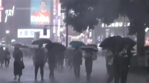Torrential rain floods streets of Tokyo at night, disrupting transport services